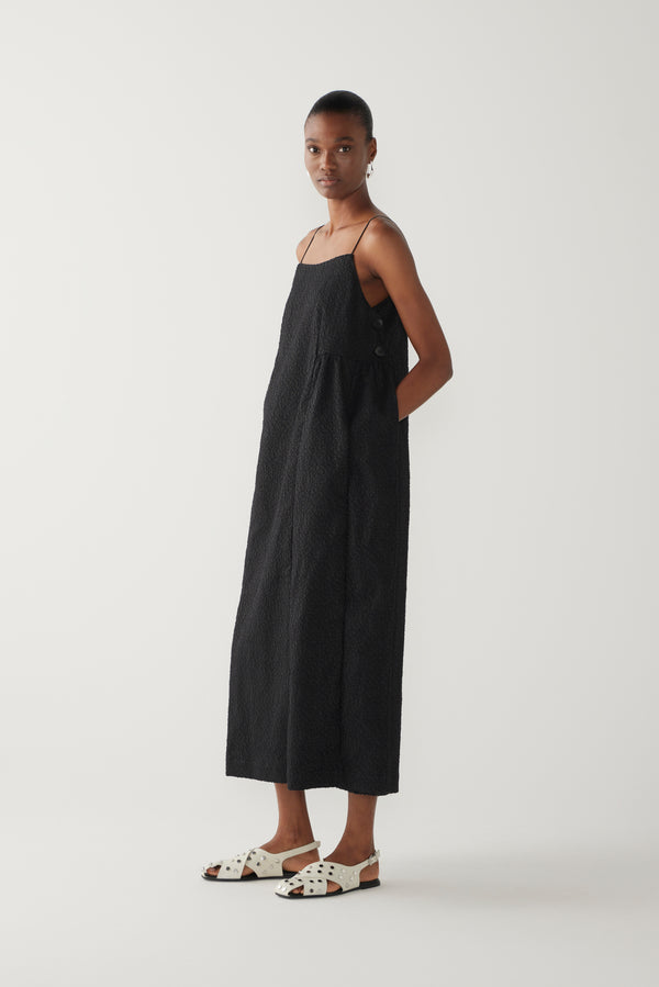 Woman wearing a black slip dress on a white background