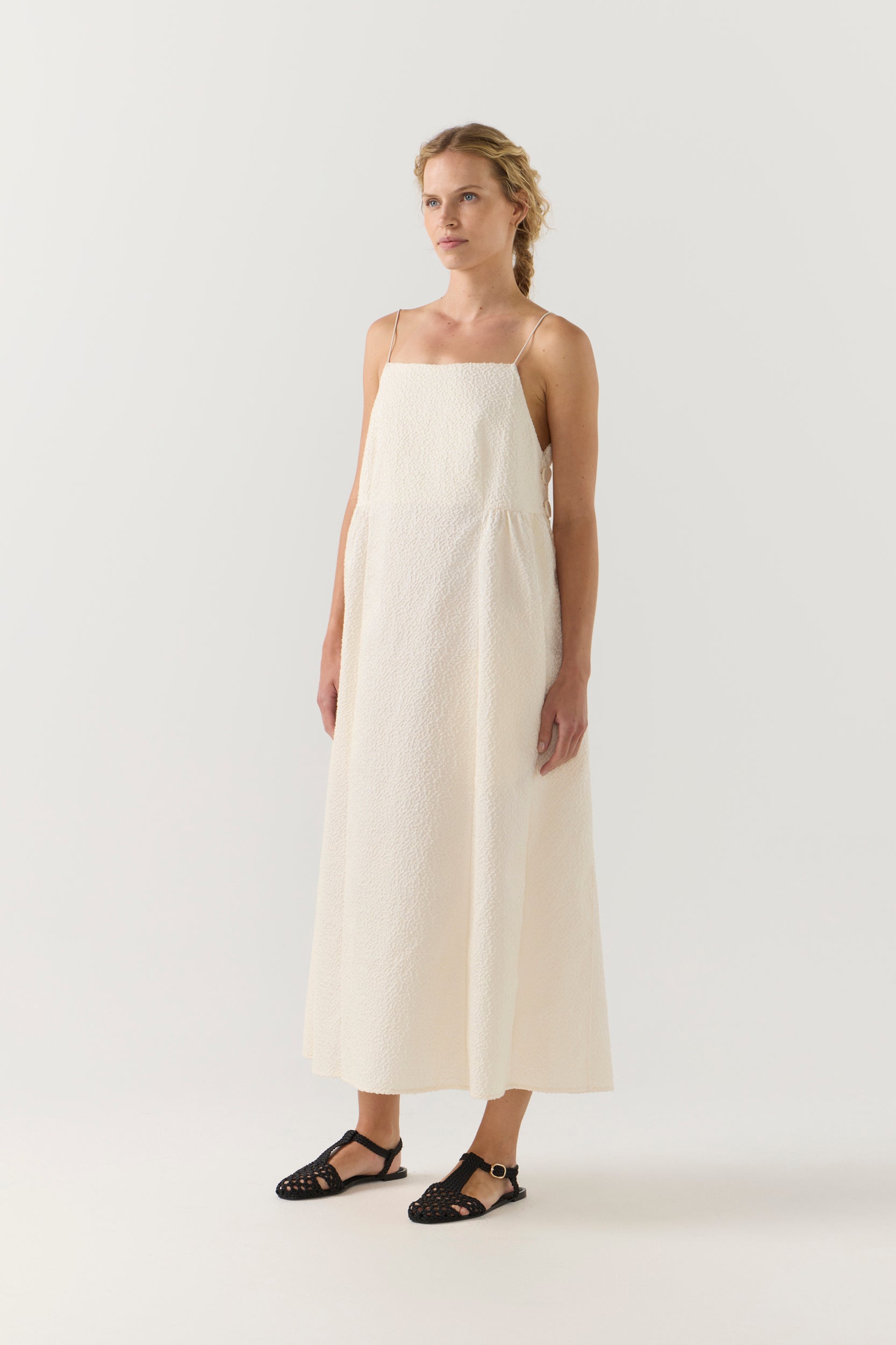 Woman wearing a white dress on a plain background