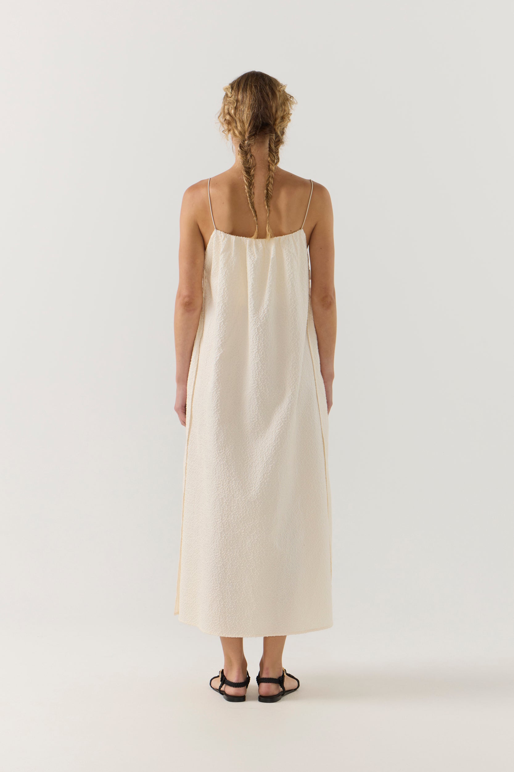 Woman wearing a white dress on a plain background