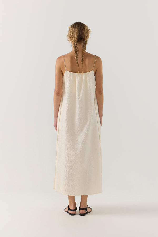 Woman wearing a white dress on a plain background