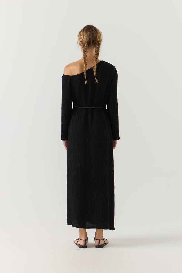 Woman wearing a black one-shoulder dress on a white background