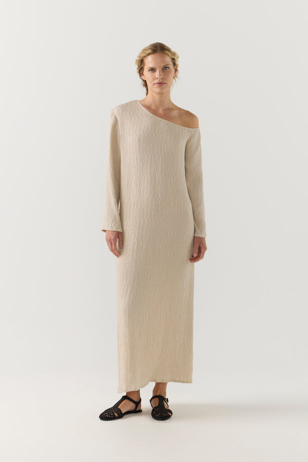 Woman wearing a beige one-shoulder dress on a white background