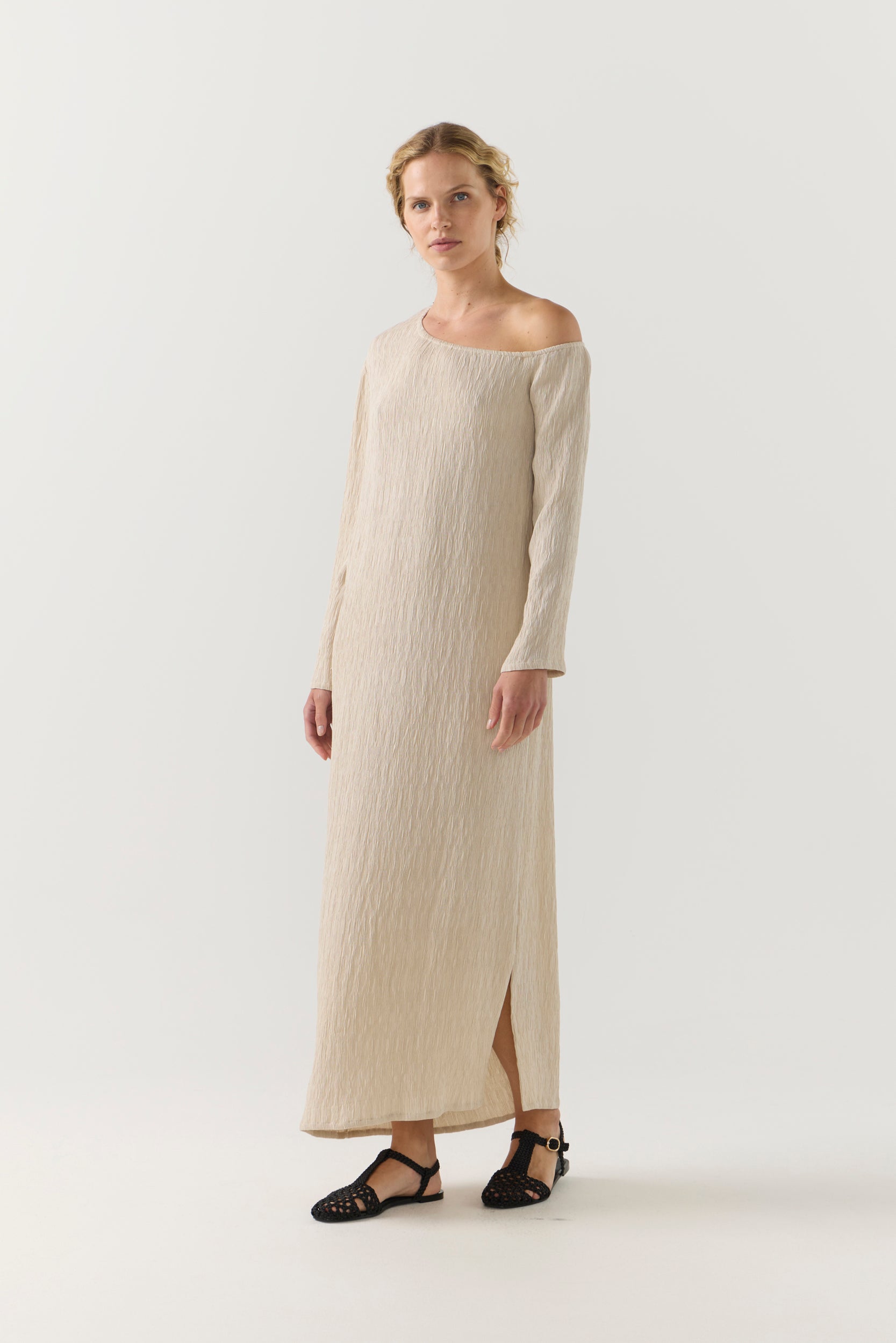 Woman wearing a beige one-shoulder dress on a white background