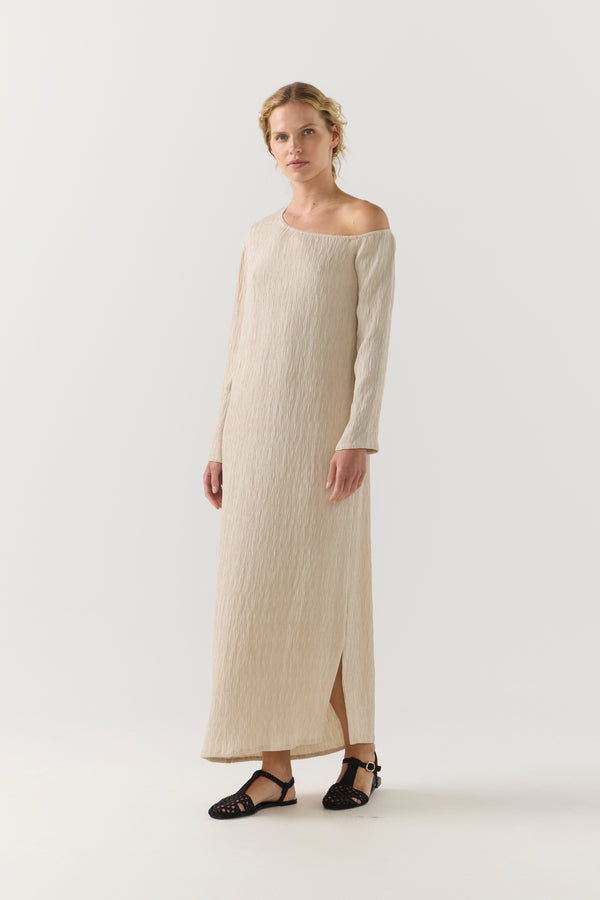 Woman wearing a beige one-shoulder dress on a white background