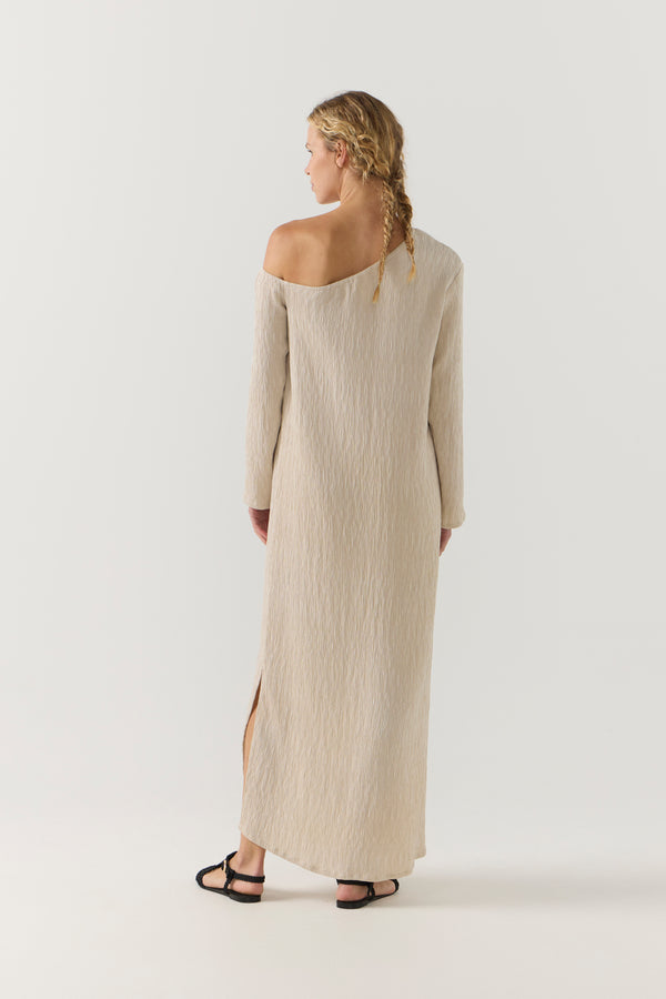 Woman wearing a beige one-shoulder dress on a white background