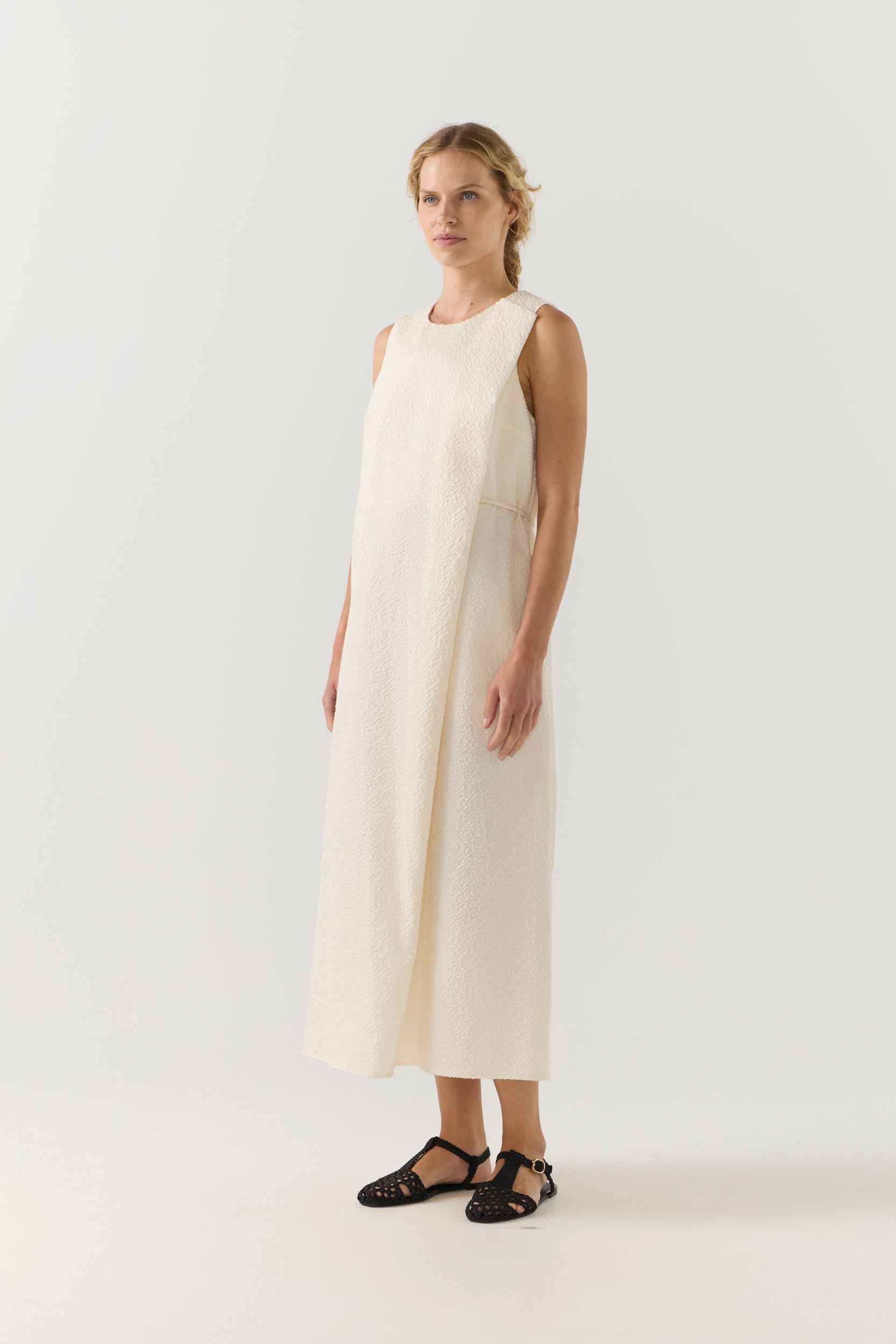 Woman wearing a white sleeveless dress on a white background