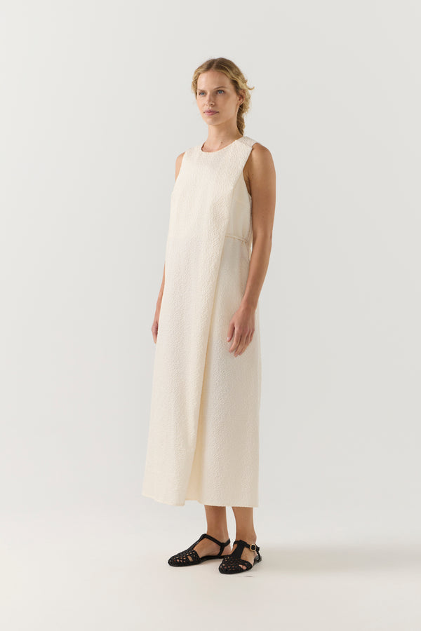 Woman wearing a white sleeveless dress on a white background