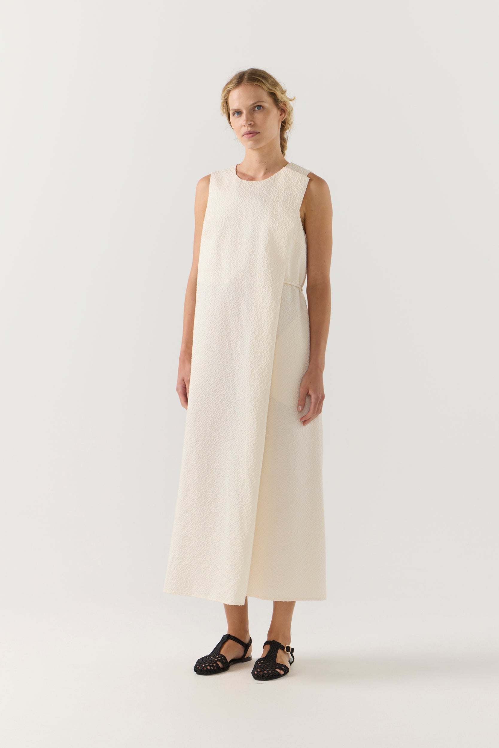 Woman wearing a white sleeveless dress on a white background