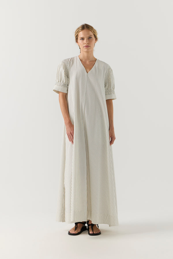 Woman wearing a white and green striped dress on a white background