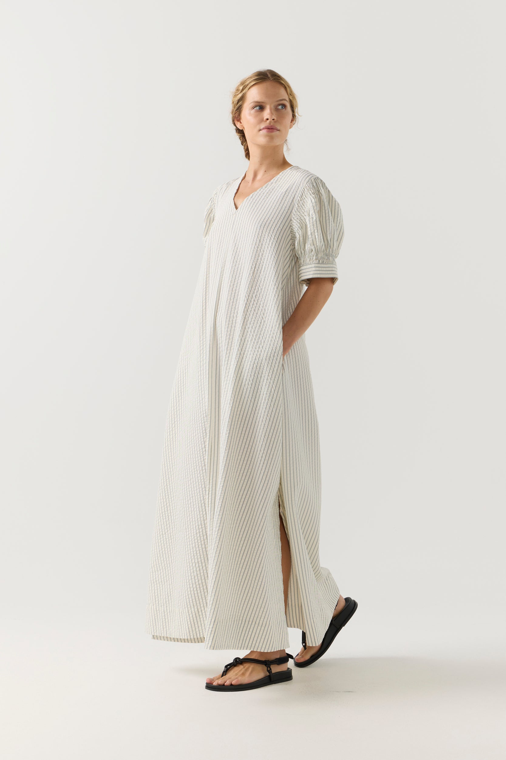 Woman wearing a white and green striped dress on a white background