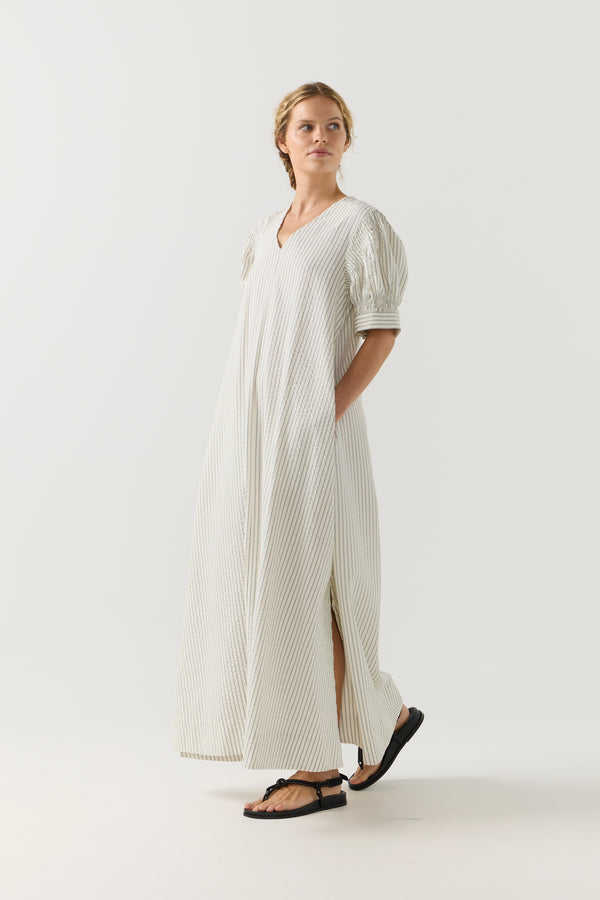 Woman wearing a white and green striped dress on a white background