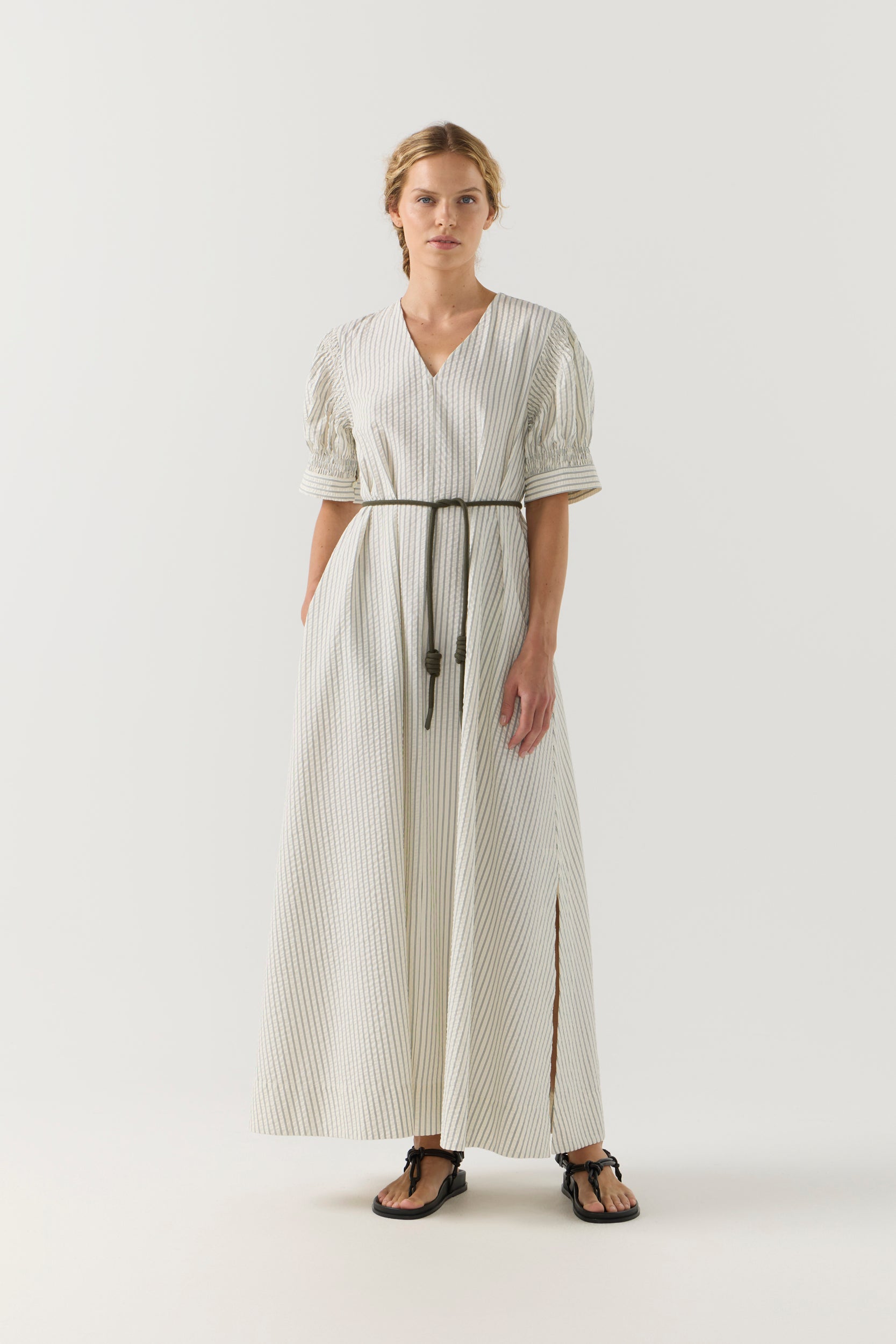 Woman wearing a white and green striped dress on a white background
