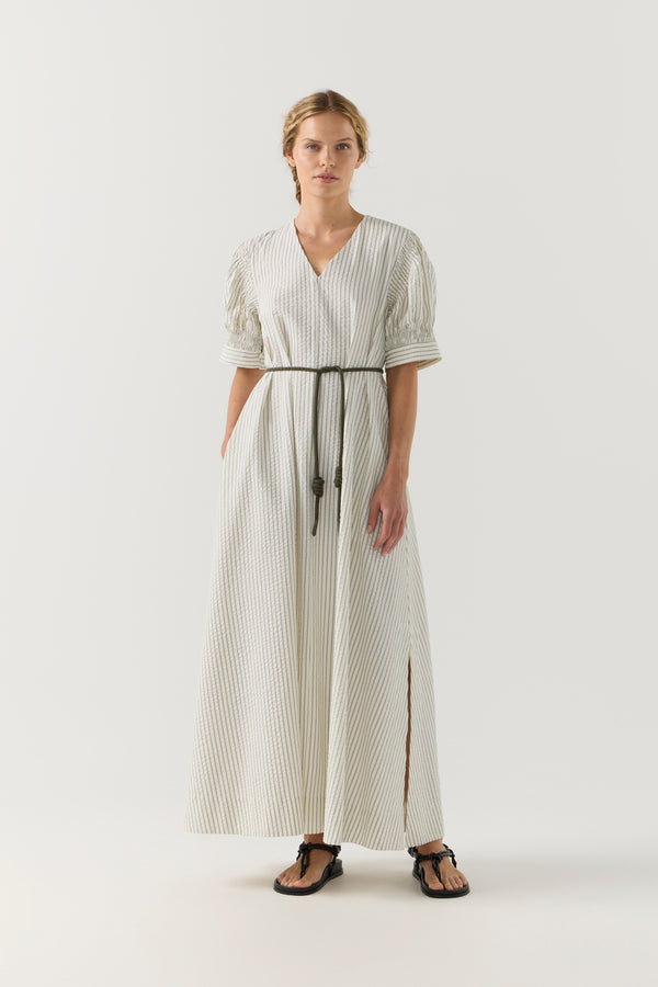 Woman wearing a white and green striped dress on a white background