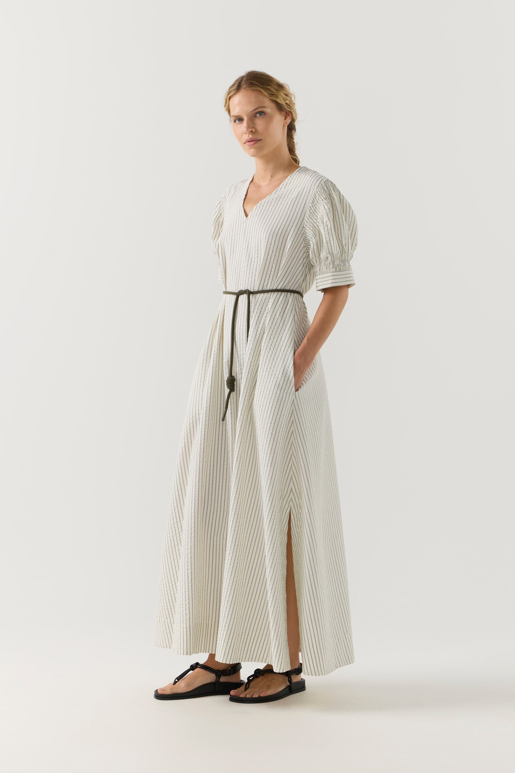 Woman wearing a white and green striped dress on a white background