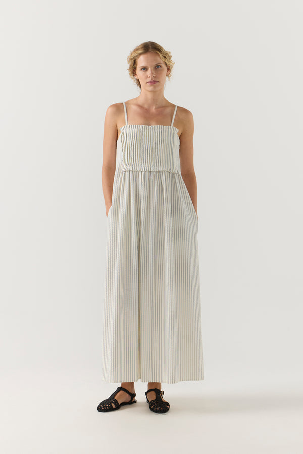 Woman wearing a white striped pleated dress on a white background