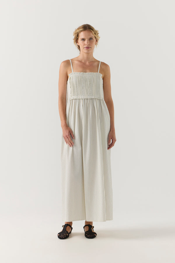 Woman wearing a white striped pleated dress on a white background